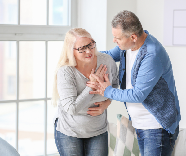 Mature Man Helping His Wife Who Is Having A Heart Attack