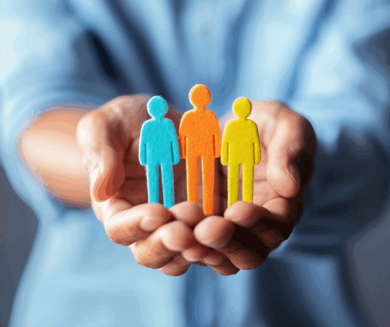 man holding three coloured felt people shapes to symbolise Safety First, Wellbeing Always