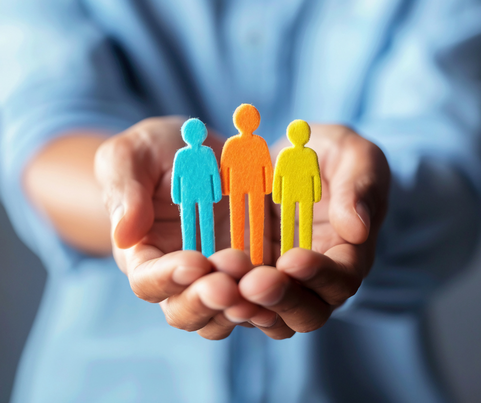man holding three coloured felt people shapes to symbolise Safety First, Wellbeing Always