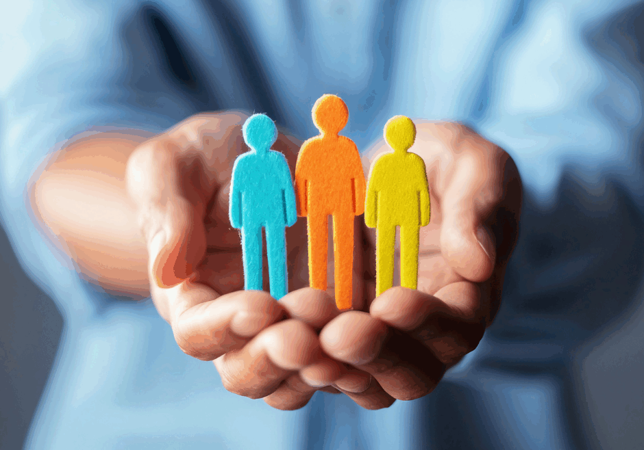 man holding three coloured felt people shapes to symbolise Safety First, Wellbeing Always